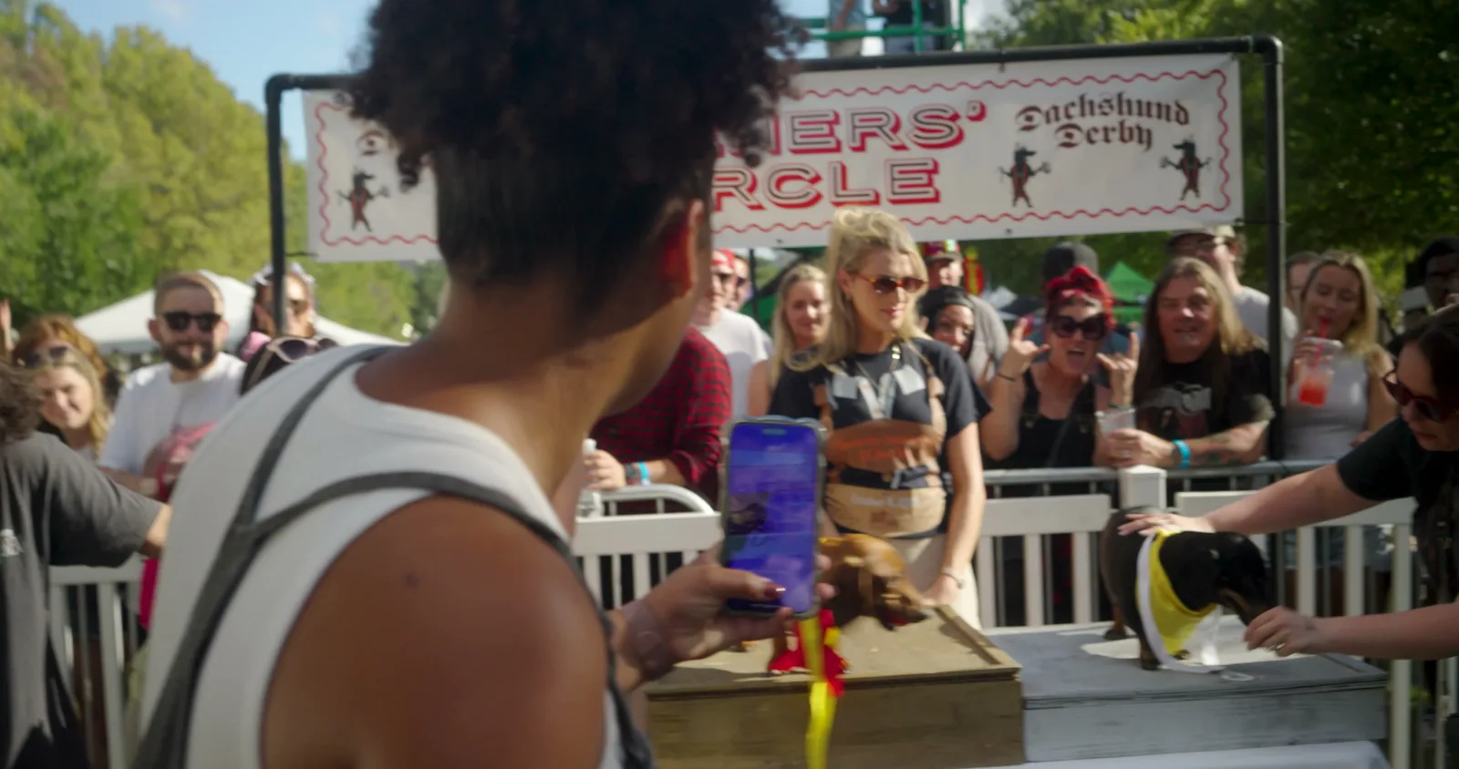 Dachshunds at the Wiener's Circle beneath the Dachshund Derby banner