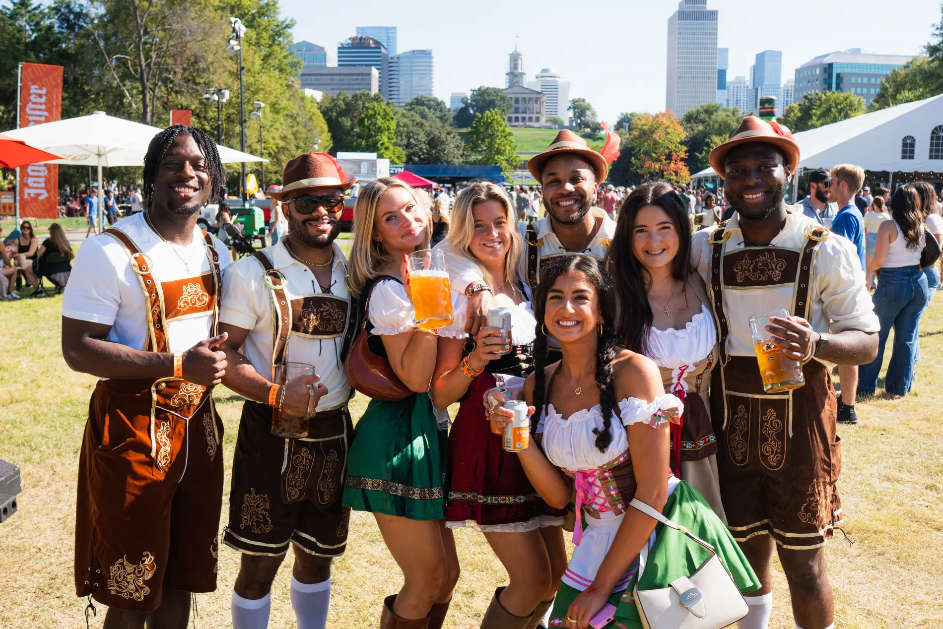 Friends celebrating at Nashville Oktoberfest with the downtown skyline behind them